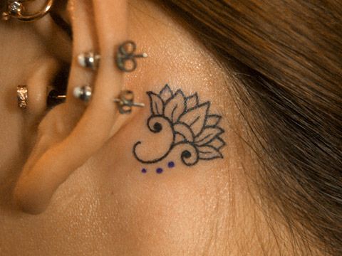 Tiny flower tattoo on the left ear  Tattoogridnet